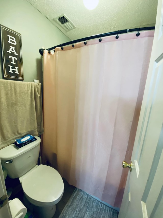 bathroom with toilet and a textured ceiling