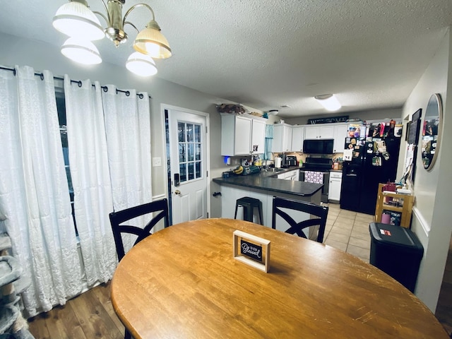 dining room featuring a textured ceiling, light hardwood / wood-style floors, and sink