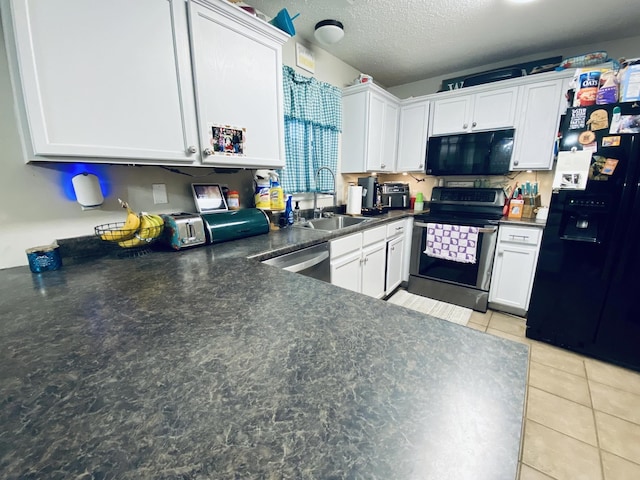 kitchen featuring a textured ceiling, sink, black appliances, light tile patterned floors, and white cabinetry