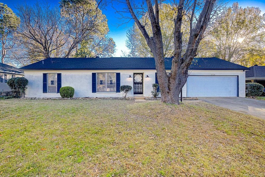 ranch-style home featuring a front yard and a garage