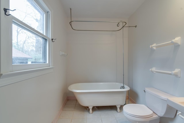 bathroom featuring toilet, tile patterned floors, and a bathtub