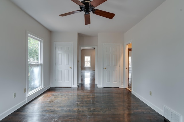 spare room with ceiling fan, a healthy amount of sunlight, and dark hardwood / wood-style floors