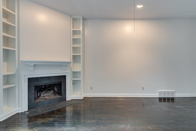 unfurnished living room featuring a fireplace, dark hardwood / wood-style floors, and built in features