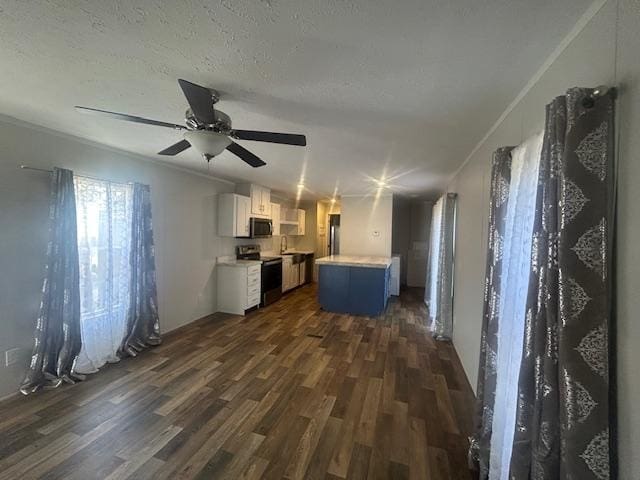 kitchen with appliances with stainless steel finishes, ceiling fan, a center island, dark hardwood / wood-style floors, and white cabinetry