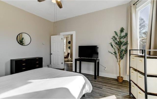 bedroom with ceiling fan and dark wood-type flooring