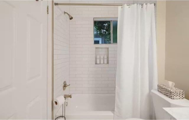 bathroom with shower / bath combo with shower curtain