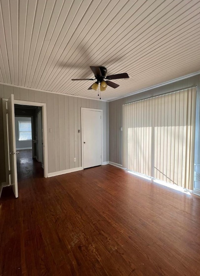 spare room featuring crown molding, ceiling fan, dark hardwood / wood-style flooring, and wooden ceiling