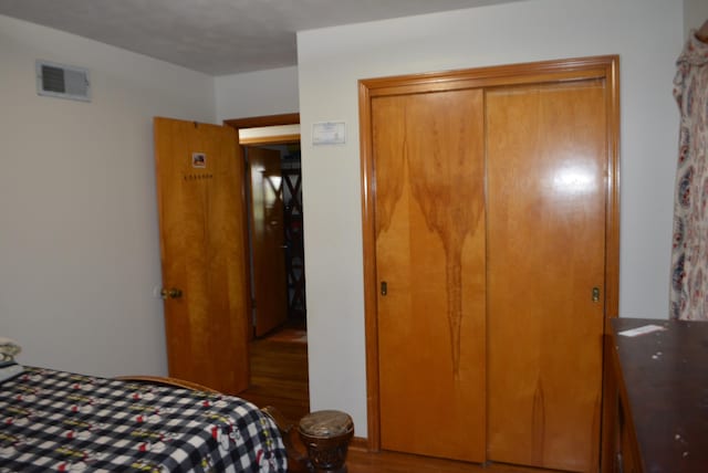 bedroom with hardwood / wood-style flooring and a closet