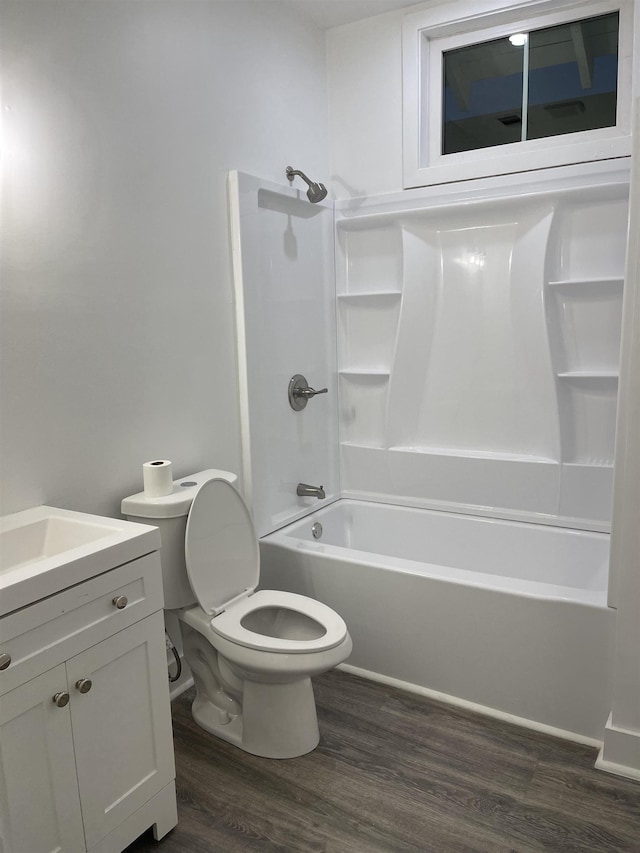 full bathroom with hardwood / wood-style flooring, vanity, toilet, and washtub / shower combination