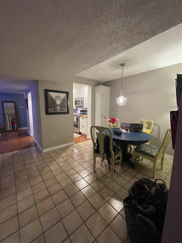 tiled dining space with a textured ceiling