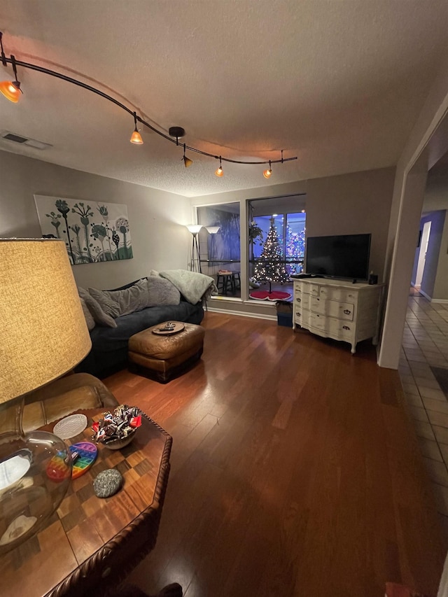 living room featuring a textured ceiling, hardwood / wood-style floors, and track lighting