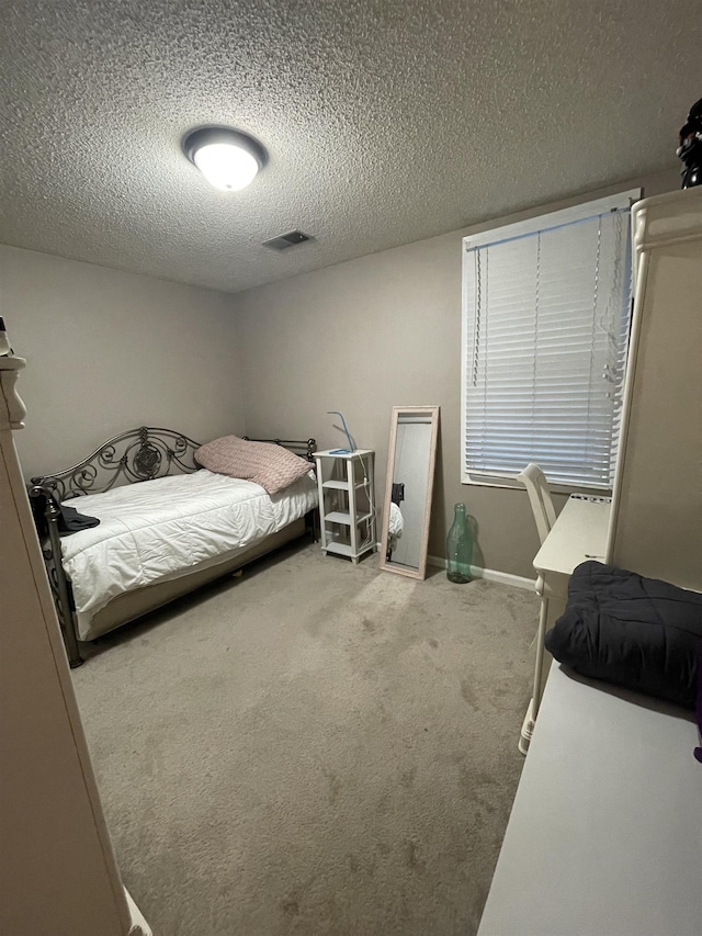 bedroom featuring carpet flooring and a textured ceiling