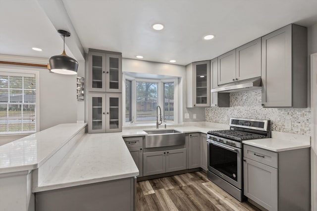 kitchen featuring gas stove, a healthy amount of sunlight, sink, and pendant lighting