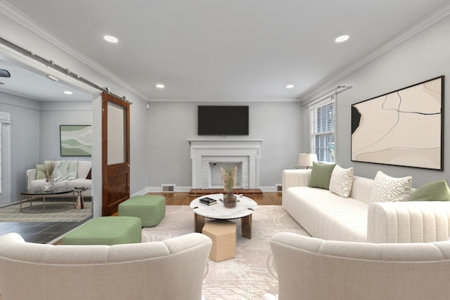 living room with a barn door, crown molding, hardwood / wood-style floors, and a fireplace