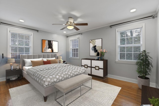 bedroom with ornamental molding, ceiling fan, and dark wood-type flooring