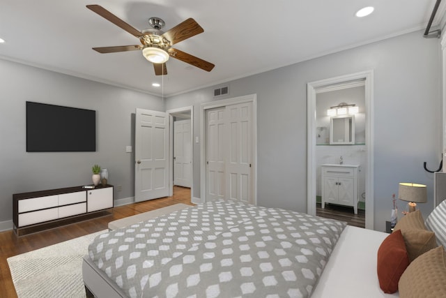 bedroom featuring ceiling fan, dark hardwood / wood-style floors, crown molding, and ensuite bath