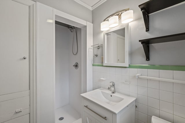 bathroom featuring vanity, crown molding, walk in shower, and tile walls