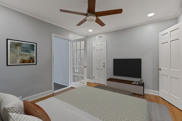 bedroom featuring ceiling fan, wood-type flooring, and ornamental molding