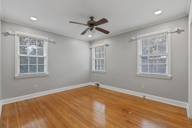 unfurnished room with hardwood / wood-style flooring, a wealth of natural light, and crown molding