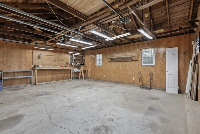 garage with a workshop area and wood walls