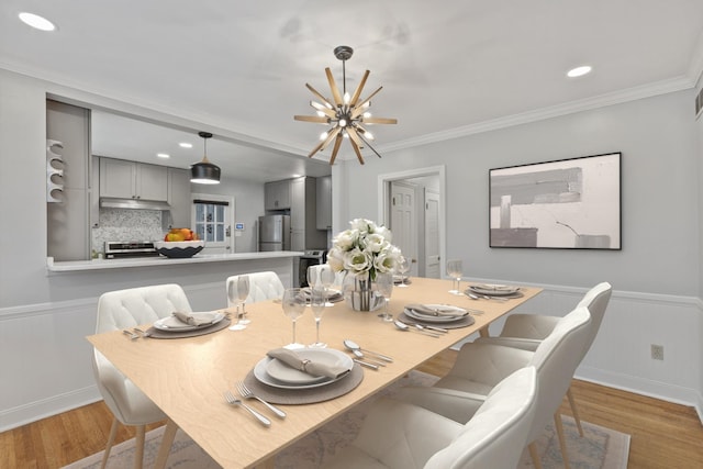 dining space featuring a chandelier, light hardwood / wood-style floors, and ornamental molding