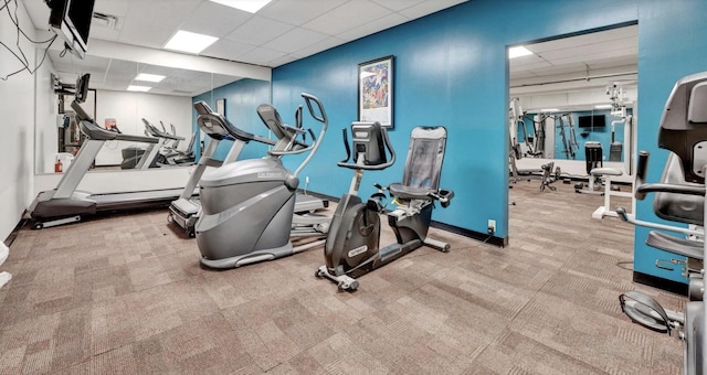 gym featuring light carpet and a paneled ceiling