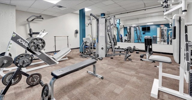 gym featuring carpet flooring and a paneled ceiling