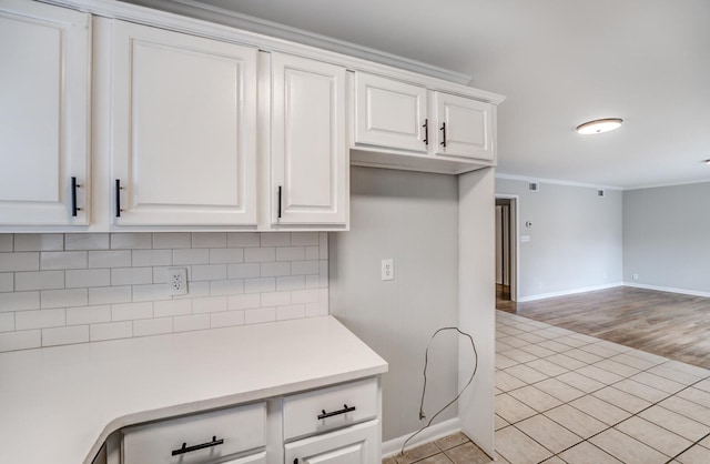 kitchen featuring white cabinetry, decorative backsplash, and light wood-type flooring