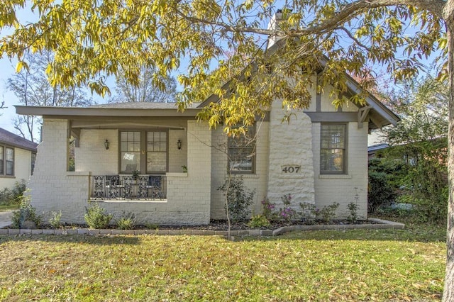 view of front of house with covered porch and a front lawn