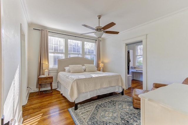 bedroom featuring ensuite bath, ceiling fan, crown molding, and light wood-type flooring