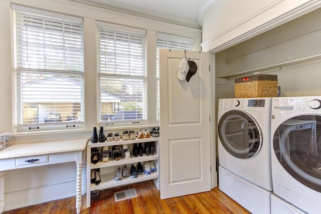 laundry room with hardwood / wood-style floors, separate washer and dryer, and ornamental molding