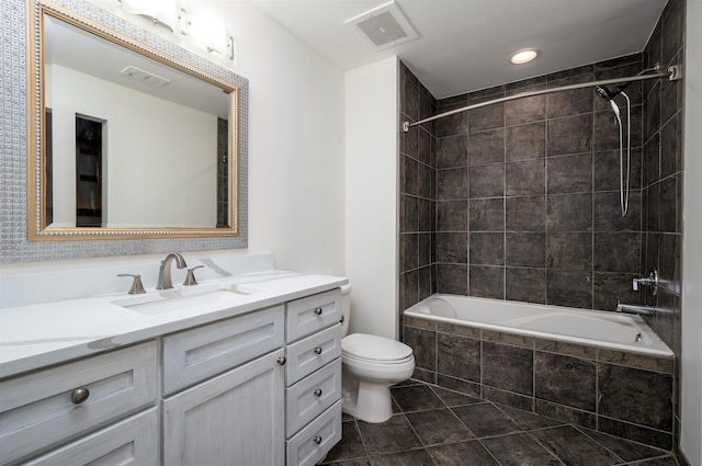 full bathroom featuring vanity, tile patterned flooring, tiled shower / bath, and toilet