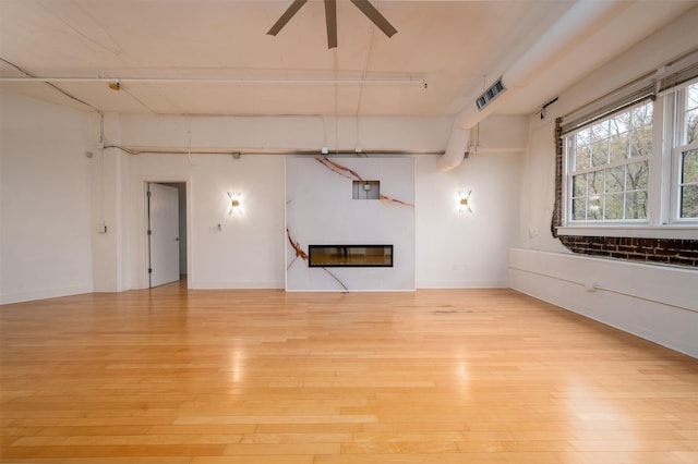 unfurnished living room with electric panel, light hardwood / wood-style flooring, and ceiling fan