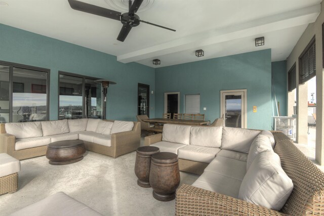 living room featuring beamed ceiling and ceiling fan