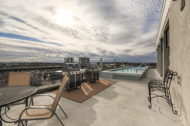 view of patio / terrace with area for grilling, a community pool, and a balcony