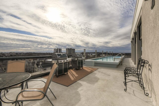 view of patio / terrace featuring a balcony, grilling area, and a community pool