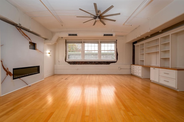 unfurnished living room with ceiling fan and light hardwood / wood-style flooring