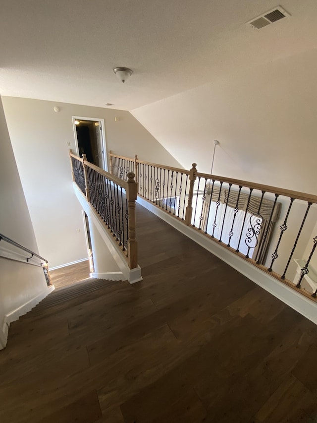 staircase with lofted ceiling and wood-type flooring