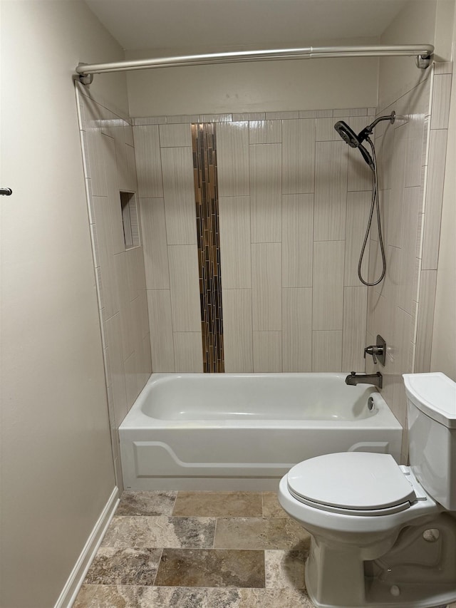 bathroom featuring tiled shower / bath combo and toilet