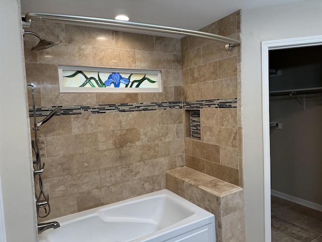 bathroom featuring tile patterned flooring, tiled shower / bath combo, and a wealth of natural light