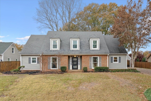 cape cod house with a front yard