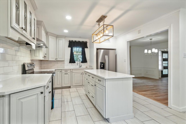 kitchen featuring a center island, stainless steel appliances, hanging light fixtures, and light hardwood / wood-style floors