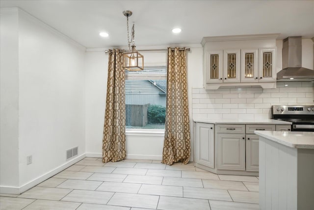 kitchen with electric range, hanging light fixtures, ornamental molding, and wall chimney range hood