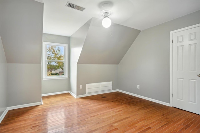 bonus room featuring light wood-type flooring and vaulted ceiling