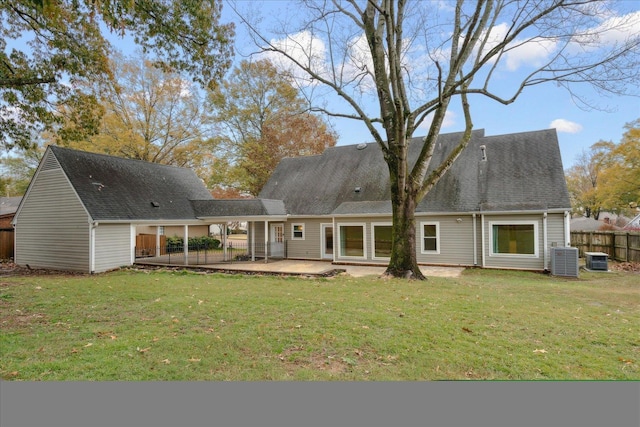 rear view of property with cooling unit, a yard, and a patio