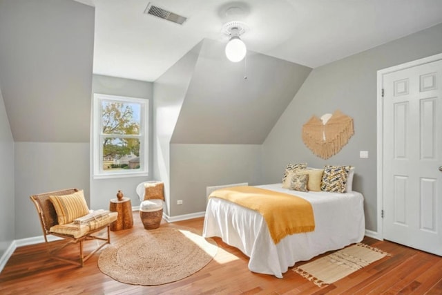 bedroom with lofted ceiling and wood-type flooring