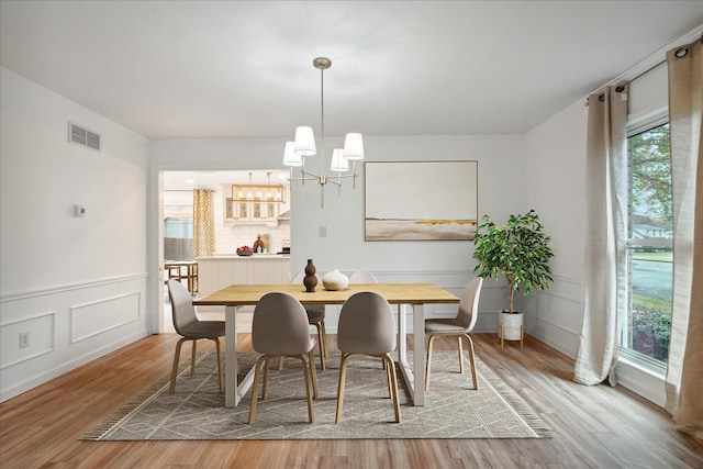 dining area featuring hardwood / wood-style flooring and a notable chandelier