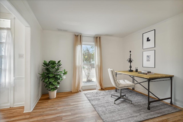 home office featuring ornamental molding and light hardwood / wood-style flooring