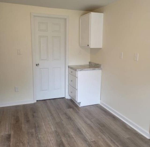 interior space with dark hardwood / wood-style flooring and white cabinetry