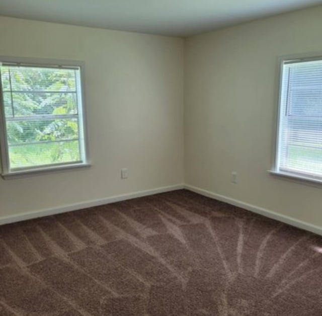 spare room with dark colored carpet